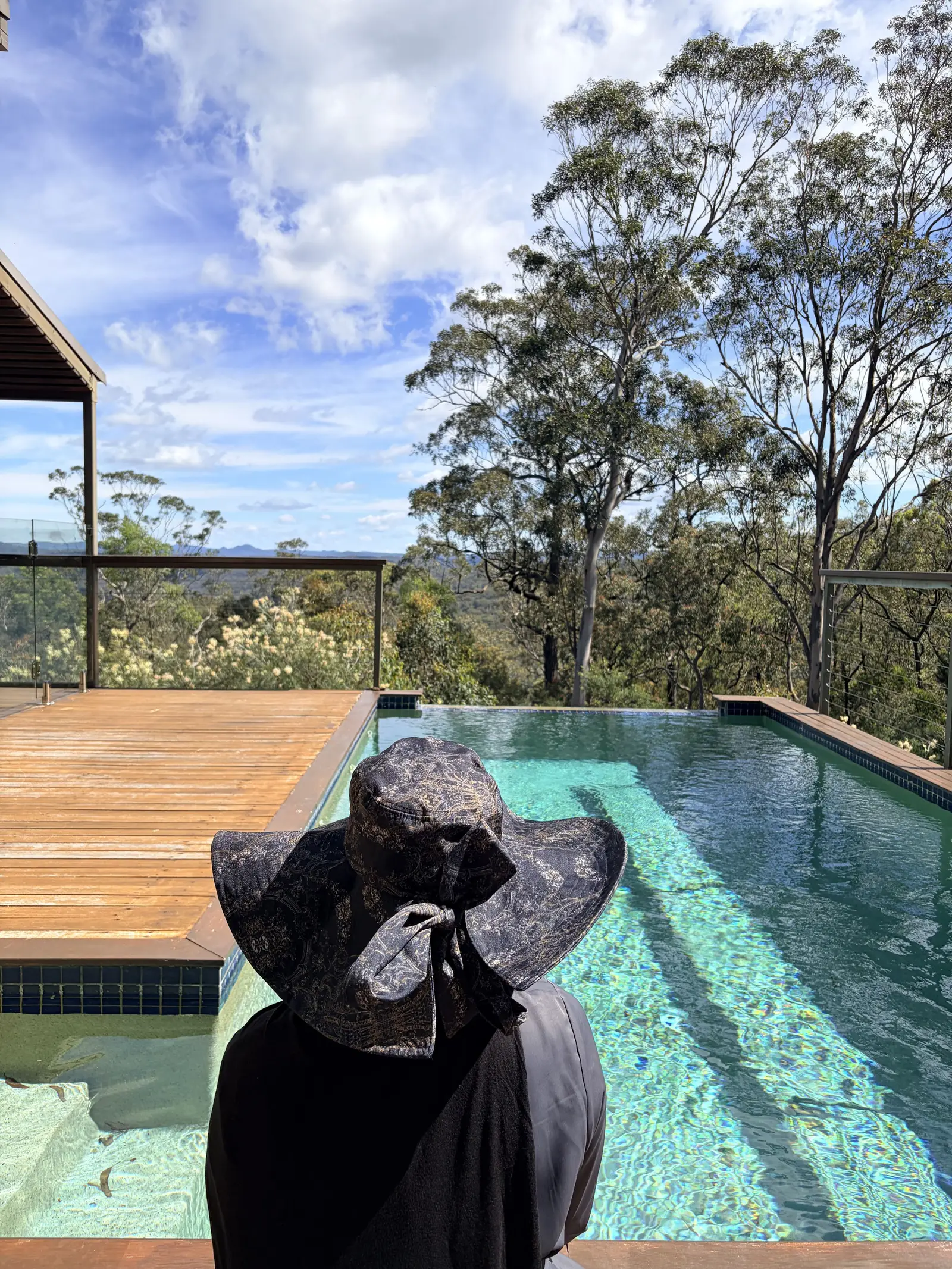 A guest beside a private infinity pool overlooking the bush