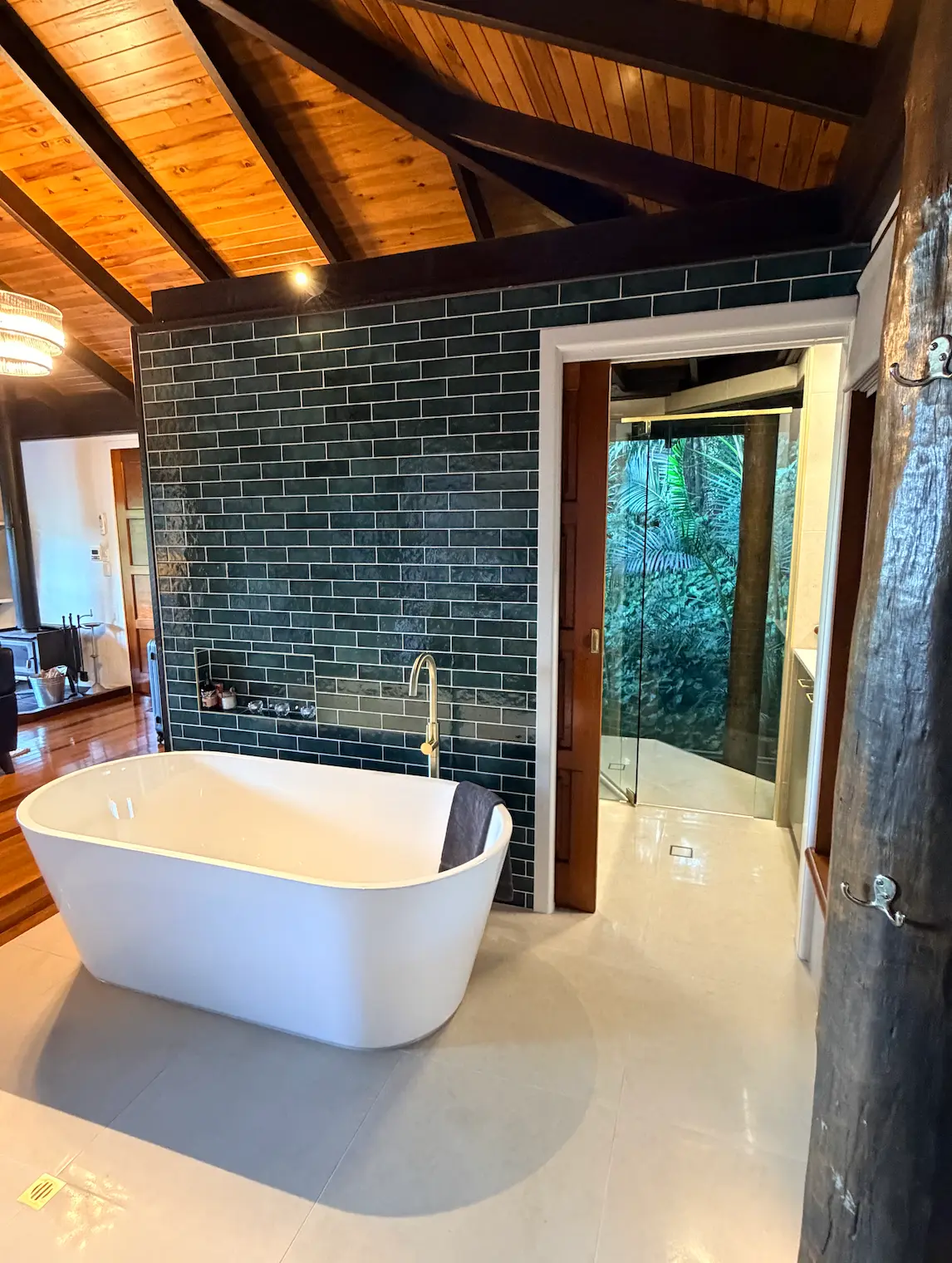 Freestanding bath against forest-green tile in the Misty View ensuite